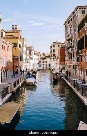 Venezia, Italia - 04 ottobre 2019: Vista classica dello stretto canale veneziano. Edifici colorati si ergono di fronte, barche ormeggiate vicino alla riva Foto Stock