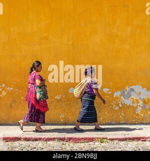 Indigeni, donne Maya che camminano per le strade colorate di Antigua, Guatemala. Foto Stock