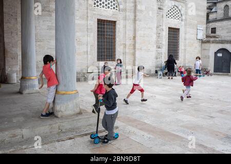 I bambini hanno preso aria fresca e hanno giocato a giocare con le loro famiglie nel cortile della Moschea del Sultano di Mihrimah. Foto Stock