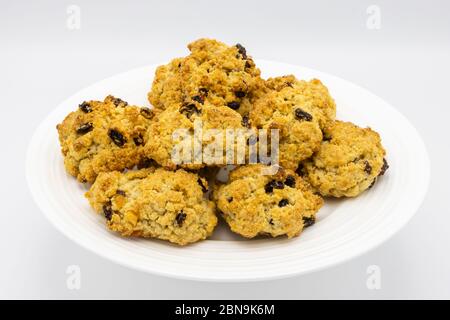 Un mucchio di deliziose torte di roccia dorate tradizionali cotte in casa presentate su un piatto bianco cinese con sfondo bianco Foto Stock