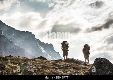 Vista ad angolo basso di due backpackers su una collina alpina Foto Stock