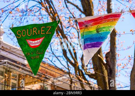 Montreal, CA - 13 maggio 2020: Souriez, CA va bien aller (sorriso, il suo andare essere ok) messaggio e disegno arcobaleno sui pennants vicino Laurier Street. Foto Stock