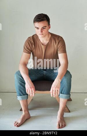 bell'uomo giovane in t-shirt e jeans da solo Foto Stock