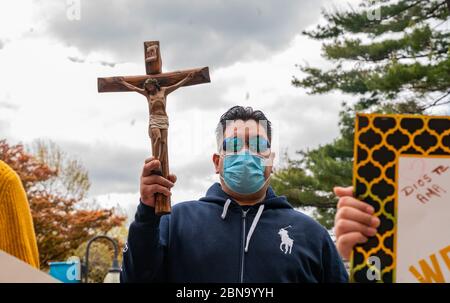 12 maggio 2020, Cambridge, Massachusetts USA: Membri della famiglia di Isabel Gonzalez che viene dimesso dall'ospedale di Spaulding COVID-19 Recovery Unit, in possesso di una croce per lei presso lo Spaulding Hospital di Cambridge. Gonzalez, 34 anni da Chelsea, ma ha contratto COVID-19 durante la sua gravidanza e ha consegnato il suo bambino Victoria attraverso la C-sezione di emergenza al Massachusts General Hospital il 30 marzo, quando è stata inizialmente ammessa. È stata trasferita in UTI il 2 aprile, intubata e ha avuto un ventilatore fino al 26 aprile. È stata ammessa allo Spaulding Hospital Cambridge il 4 maggio ed ora ha un test Foto Stock