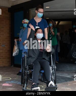 12 maggio 2020, Spaulding Hospital, Cambridge, Massachusetts USA: Isabel Gonzalez sventola alla sua famiglia e ai suoi amici allo Spaulding Hospital Cambridge COVID-19 Recovery Unit a Cambridge. Ha testato COVID negativo e si è ripresa e dimessa dall'ospedale. Gonzalez, 34 anni da Chelsea, ma, incinta quando ha contratto il COVID-19, ha consegnato il suo bambino Victoria attraverso la sezione C di emergenza al Massachusts General Hospital il 30 marzo, quando è stata inizialmente ammessa. È stata trasferita in UTI il 2 aprile, intubata e ha avuto un ventilatore fino al 26 aprile. È stata ammessa Foto Stock