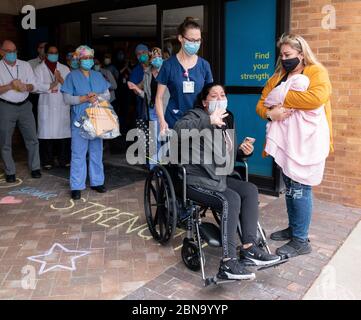 12 maggio 2020, Spaulding Hospital, Cambridge, Massachusetts USA: Isabel Gonzalez che si è alacata alla sua famiglia e amici è stato dimesso dal Spaulding Hospital Cambridge COVID-19 Recovery Unit a Cambridge. Gonzalez, 34 anni da Chelsea, ma, incinta quando ha contratto il COVID-19, ha consegnato il suo bambino Victoria attraverso la sezione C di emergenza al Massachusts General Hospital il 30 marzo, quando è stata inizialmente ammessa. È stata trasferita in UTI il 2 aprile, intubata e ha avuto un ventilatore fino al 26 aprile. È stata ammessa allo Spaulding Hospital Cambridge il 4 maggio ed ora ha testato Foto Stock