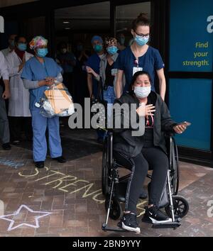 12 maggio 2020, Spaulding Hospital, Cambridge, Massachusetts USA: Isabel Gonzalez dimesso dalla Spaulding Hospital Cambridge COVID-19 Recovery Unit di Cambridge. Gonzalez, 34 anni da Chelsea, ma, incinta quando ha contratto il COVID-19, ha consegnato il suo bambino Victoria attraverso la sezione C di emergenza al Massachusts General Hospital il 30 marzo, quando è stata inizialmente ammessa. È stata trasferita in UTI il 2 aprile, intubata e ha avuto un ventilatore fino al 26 aprile. È stata ricoverata allo Spaulding Hospital Cambridge il 4 maggio ed ora ha testato COVID negativo e recuperato. Lei io Foto Stock