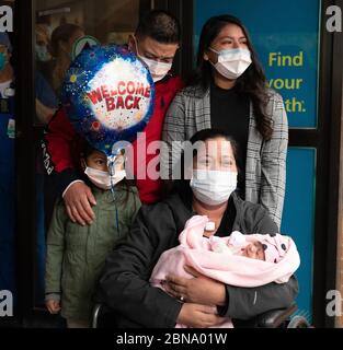 12 maggio 2020, Cambridge, Massachusetts USA: Isabel Gonzalez vede il suo bambino Victoria per la prima volta, quando è dimessa dal COVID-19 Recovery Unit Spaulding Hospital di Cambridge. Gonzalez, 34 anni da Chelsea, ma, incinta quando ha contratto il COVID-19, ha consegnato il suo bambino Victoria attraverso la sezione C di emergenza al Massachusts General Hospital il 30 marzo, quando è stata inizialmente ammessa. È stata trasferita in UTI il 2 aprile, intubata e ha avuto un ventilatore fino al 26 aprile. È stata ammessa allo Spaulding Hospital Cambridge il 4 maggio ed ora ha testato COVID negativo a Foto Stock