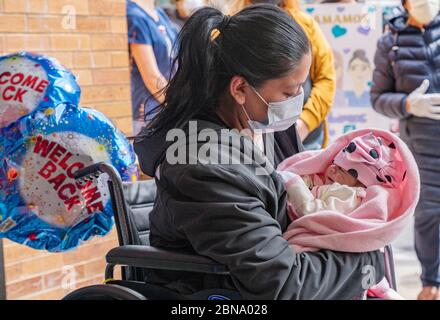 12 maggio 2020, Cambridge, Massachusetts USA: Isabel Gonzalez vede il suo bambino Victoria per la prima volta, quando è dimessa dal COVID-19 Recovery Unit Spaulding Hospital di Cambridge. Gonzalez, 34 anni da Chelsea, ma, incinta quando ha contratto il COVID-19, ha consegnato il suo bambino Victoria attraverso la sezione C di emergenza al Massachusts General Hospital il 30 marzo, quando è stata inizialmente ammessa. È stata trasferita in UTI il 2 aprile, intubata e ha avuto un ventilatore fino al 26 aprile. È stata ammessa allo Spaulding Hospital Cambridge il 4 maggio ed ora ha testato COVID negativo a Foto Stock