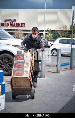 LOS ANGELES, STATI UNITI - 05 aprile 2020: Un membro del personale del mercato agricolo duro al lavoro che indossa una maschera facciale durante l'epidemia di COVID-19. Foto Stock