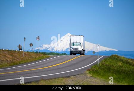 Grande carro di sollevamento con cofano Day Cab diesel semi-camion per consegne locali che trasportano carichi commerciali in furgone a secco semi-rimorchio che corre su strada stretta e divisa int Foto Stock