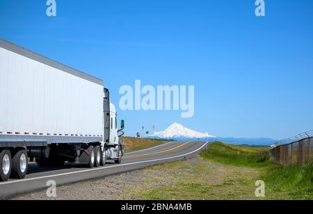 Grande carro di sollevamento con cofano Day Cab diesel semi-camion per consegne locali che trasportano carichi commerciali in furgone a secco semi-rimorchio che corre su strada stretta e divisa int Foto Stock