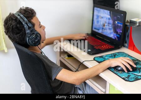 Poco dipendente Ragazzo giocatore a giocare sul portatile a casa Foto Stock