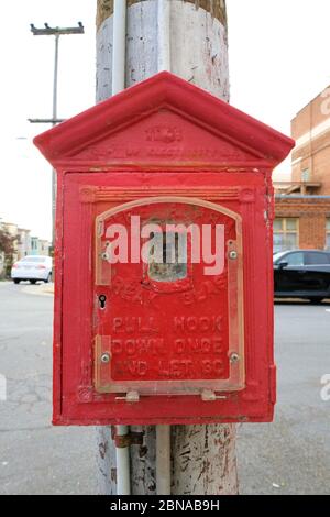 Una scatola di chiamata di allarme antincendio utilizzata per notificare al reparto antincendio un incendio; tecnologia all'inizio del XX secolo; trovata in un angolo a San Francisco, California. Foto Stock