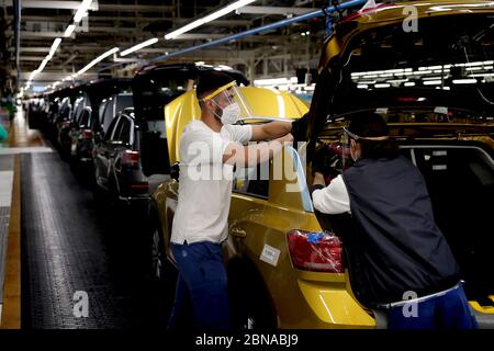 Lisbona, Portogallo. 13 maggio 2020. I dipendenti che indossano maschere facciali lavorano sulla linea di assemblaggio presso la fabbrica di automobili Volkswagen Autoeuropa a Palmela, Portogallo, 13 maggio 2020. Il presidente portoghese Marcelo Rebelo de Sousa e il primo ministro Antonio Costa mercoledì hanno incoraggiato tutte le industrie a ricominciare in condizioni severe in mezzo alla pandemia COVID-19, ha riferito l'Agenzia di notizie di Lusa. Dopo la visita congiunta all'impianto di assemblaggio automobilistico Autoeuropa, i due leader hanno espresso la loro fiducia nella ripresa della produzione per il produttore automobilistico. Credit: Pedro Feuza/Xinhua/Alamy Live News Foto Stock