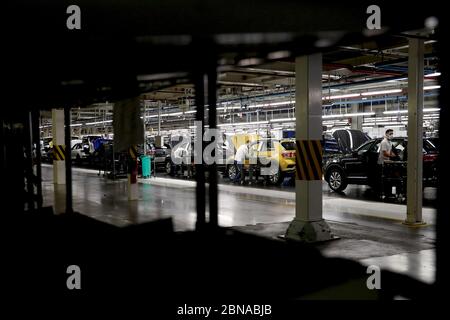 Lisbona, Portogallo. 13 maggio 2020. I dipendenti che indossano maschere facciali lavorano sulla linea di assemblaggio presso la fabbrica di automobili Volkswagen Autoeuropa a Palmela, Portogallo, 13 maggio 2020. Il presidente portoghese Marcelo Rebelo de Sousa e il primo ministro Antonio Costa mercoledì hanno incoraggiato tutte le industrie a ricominciare in condizioni severe in mezzo alla pandemia COVID-19, ha riferito l'Agenzia di notizie di Lusa. Dopo la visita congiunta all'impianto di assemblaggio automobilistico Autoeuropa, i due leader hanno espresso la loro fiducia nella ripresa della produzione per il produttore automobilistico. Credit: Pedro Feuza/Xinhua/Alamy Live News Foto Stock