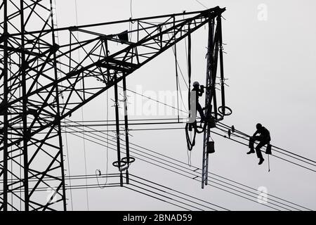 Ingegneri ad alta tensione che lavorano su piloni ad alta tensione, Baden-Württemberg, Germania, Europa Foto Stock