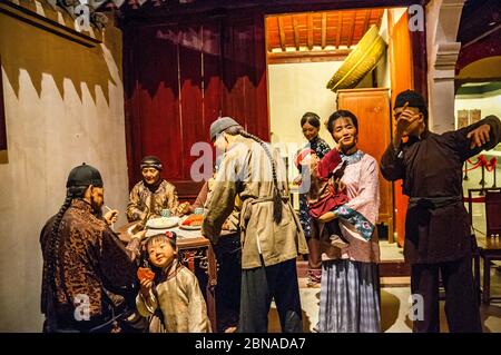 Un display da Ningbo museo che rappresenta una famiglia di Qing scena guardando la metà autunno luna e una ragazza a mangiare una torta della luna Foto Stock