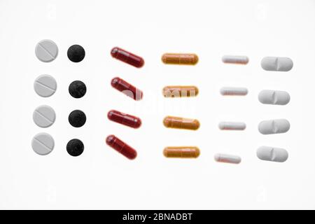 Ha allineato diverse compresse colorate, capsule, pillole e dragées di fronte a uno sfondo bianco, Germania, Europa Foto Stock