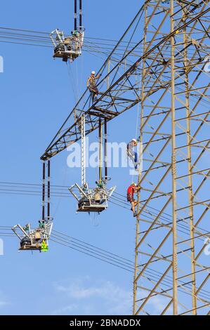 Ingegneri ad alta tensione che lavorano sul pilone ad alta tensione, Baden-Württemberg, Germania, Europa Foto Stock