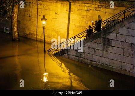 PARIGI, FRANCIA - 05 giugno 2016: Parigi / Francia. 2016. I passanti scattano foto dal fiume inondato quais de la Seine, a Parigi, di notte. Foto Stock