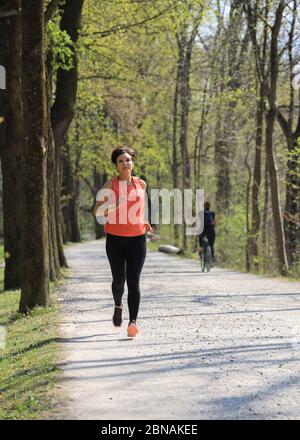 Donna, 40-45 anni, jogging in una zona forestale a Monaco, Baviera, Germania. Foto Stock