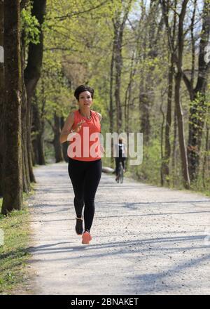 Donna, 40-45 anni, jogging in una zona forestale a Monaco, Baviera, Germania. Foto Stock