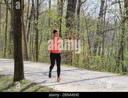 Donna, 40-45 anni, jogging in una zona forestale a Monaco, Baviera, Germania. Foto Stock