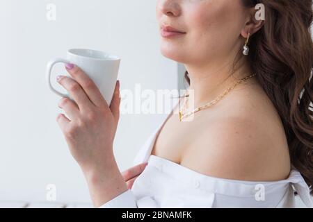 Mano della donna che tiene una tazza bianca di caffè. Con un bellissimo manicure primo piano. Drink, moda, mattina Foto Stock