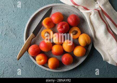 Composizione con vassoio di albicocche su fondo cementizio Foto Stock