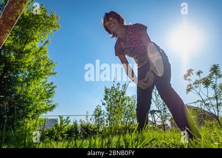 Una ragazza gioca badminton in una compensazione. Passatempo estivo Foto Stock