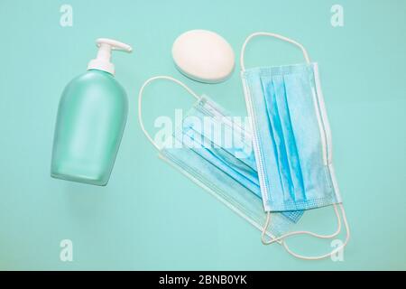 Medico, maschere facciali, disinfettante e sapone antibatterico su sfondo blu. Concetto di protezione contro Covid 19, Corona Virus, infezione batterica Foto Stock