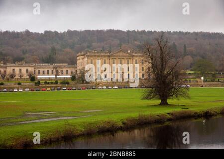 Regno Unito, Inghilterra, Derbyshire, Edensor, Chatsworth House attraverso il fiume Derwent in inverno Foto Stock