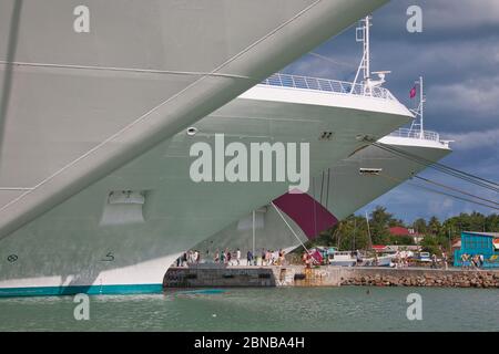 I gomiti di tre navi da crociera ormeggiate nel porto di St Johns ad Antigua, Caraibi, Indie Occidentali Foto Stock