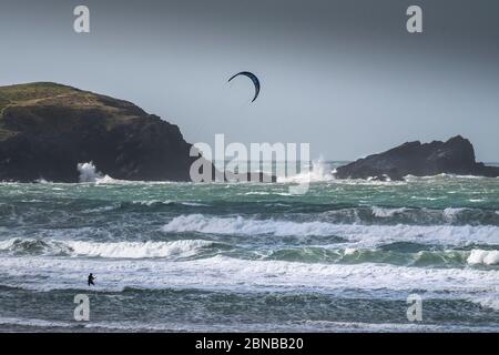 Un solista kite boarder che affronta le condizioni selvagge del vento a Fistral a Newquay in Cornovaglia. Foto Stock