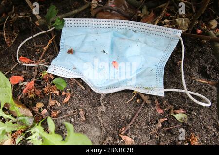 Amburgo, Germania. 13 maggio 2020. Una guardia della bocca (bocca e maschera del naso) è sdraiata nei cespugli lungo una strada. Credit: Marco Bodo/dpa/Marco Bodo/dpa/Alamy Live News Foto Stock