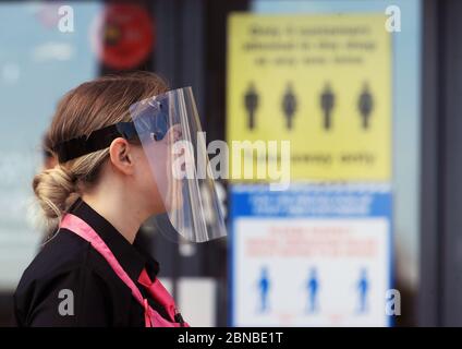 Il personale del negozio di pesce e patatine e della gelateria sulla spiaggia di Blyth, Northumberland, indossa i dispositivi di protezione individuale (PPE) mentre mettono i cartelli di allontanamento sociale per i clienti. Il ristorante ha riaperto per ordini di take away dopo l'allentamento delle restrizioni di blocco durante la pandemia del coronavirus. Foto Stock