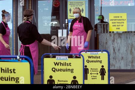 Il personale del negozio di pesce e patatine e della gelateria sulla spiaggia di Blyth, Northumberland, indossa i dispositivi di protezione individuale (PPE) mentre mettono i cartelli di allontanamento sociale per i clienti. Il ristorante ha riaperto per ordini di take away dopo l'allentamento delle restrizioni di blocco durante la pandemia del coronavirus. Foto Stock