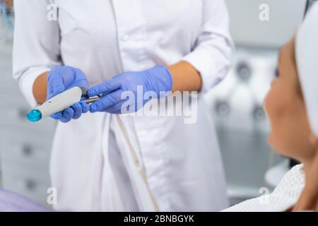 Medico che tiene un dispositivo di idrodermabrasion nelle sue mani Foto Stock