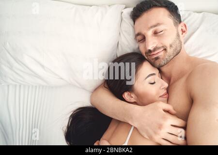 Giovane sposato coppia caucasica riposante a letto Foto Stock