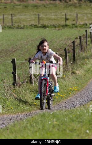 Giovane ragazza in bicicletta su una mountain bike sulla corsia di campagna Foto Stock