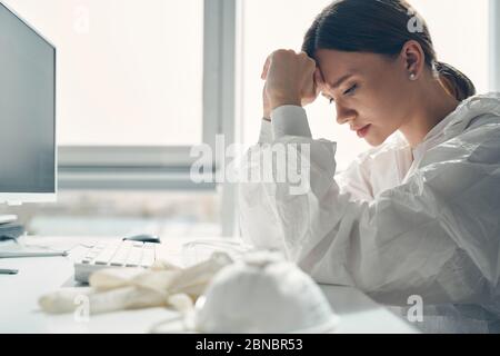 Turbata giovane donna che si sente stanca e stressata sul lavoro Foto Stock