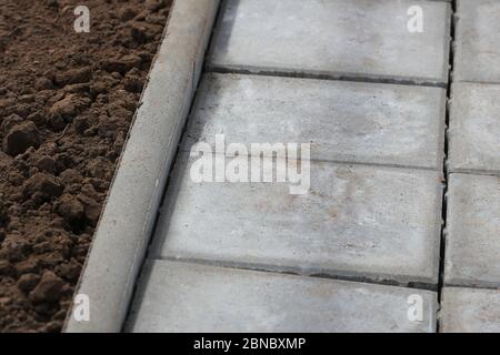 Lastre o pietre quadrate in cemento o ciottoli per marciapiede, pavimentazione stradale Foto Stock