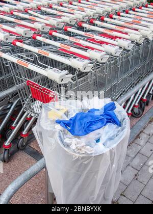 Cremona, Lombardia, Italia - 13 maggio 2020 - rifiuti e lattine nei pressi dei carrelli per lo shopping fuori dal supermercato covid Times , nessuna gente Foto Stock