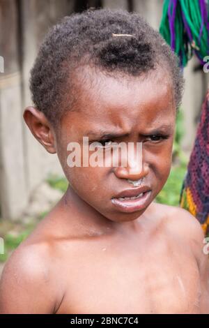 Wamena, Indonesia - 9 gennaio 2010: Portret del ragazzo della tribù Dani. Ragazzino che guarda la macchina fotografica. Baliem Valley in Indonesia, Papua Nuova Guinea. Foto Stock