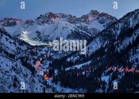 Paesaggio di strada incandescente da Medeu ghiaccio skate a Shymbulak stazione sciistica a Tian Shan montagna in serata a Almaty, Kazakistan Foto Stock