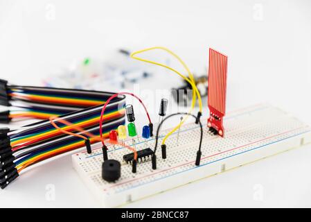 Microcontrollori, chip, resistori e diodi ad emissione luminosa su desktop bianco di un tecnico hardware. Progettare il luogo di lavoro Foto Stock