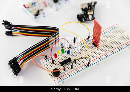 Microcontrollori, chip, resistori e diodi ad emissione luminosa su desktop bianco di un tecnico hardware. Progettare il luogo di lavoro Foto Stock