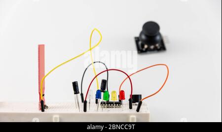 Microcontrollori, chip, resistori e diodi ad emissione luminosa su desktop bianco di un tecnico hardware. Progettare il luogo di lavoro Foto Stock