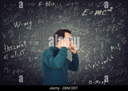 Il tipo di studente esausto di apprendimento costante sente mal di testa, non può mettere a fuoco la sua mente sullo studio. L'uomo soffre di dolore alla testa, problemi di salute mentale dopo solvi Foto Stock